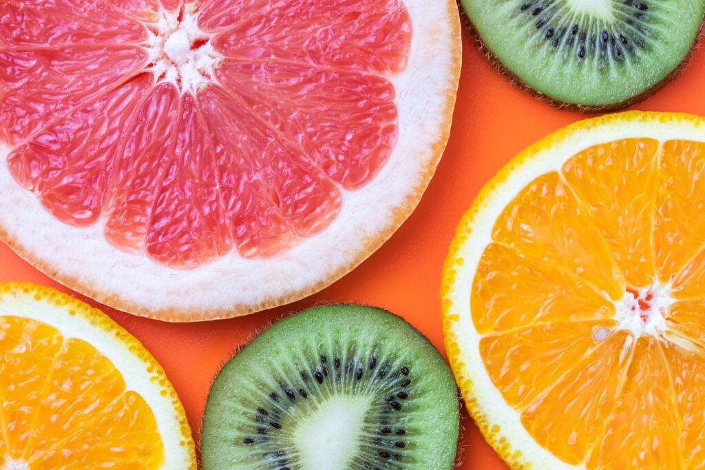 Colorful pattern of citrus fruits slices on orange color background. Top view